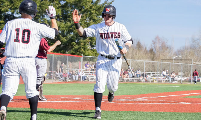 Cody Poznanski congratulates Garret Harpole after scoring one of his eight runs this weekend against Central Washington.